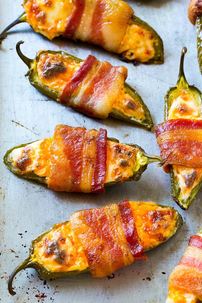 A sheet pan with bacon wrapped jalapeno poppers.