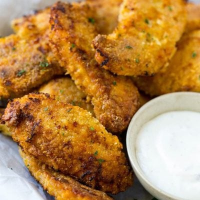 Crispy baked chicken fingers on a plate with ranch dip.