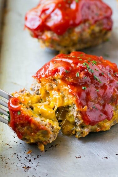 A cheeseburger meatloaf with a fork pulling a piece away.