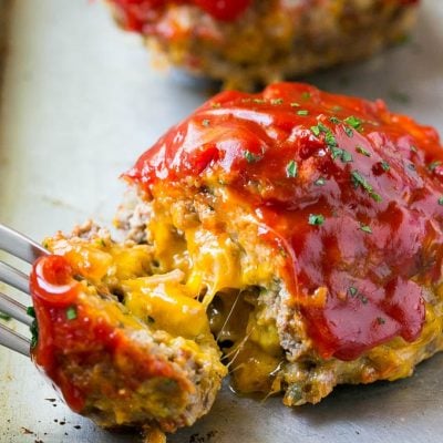 A cheeseburger meatloaf with a fork pulling a piece away.