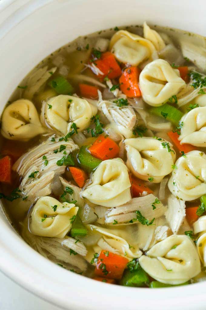 A slow cooker full of chicken tortellini soup.