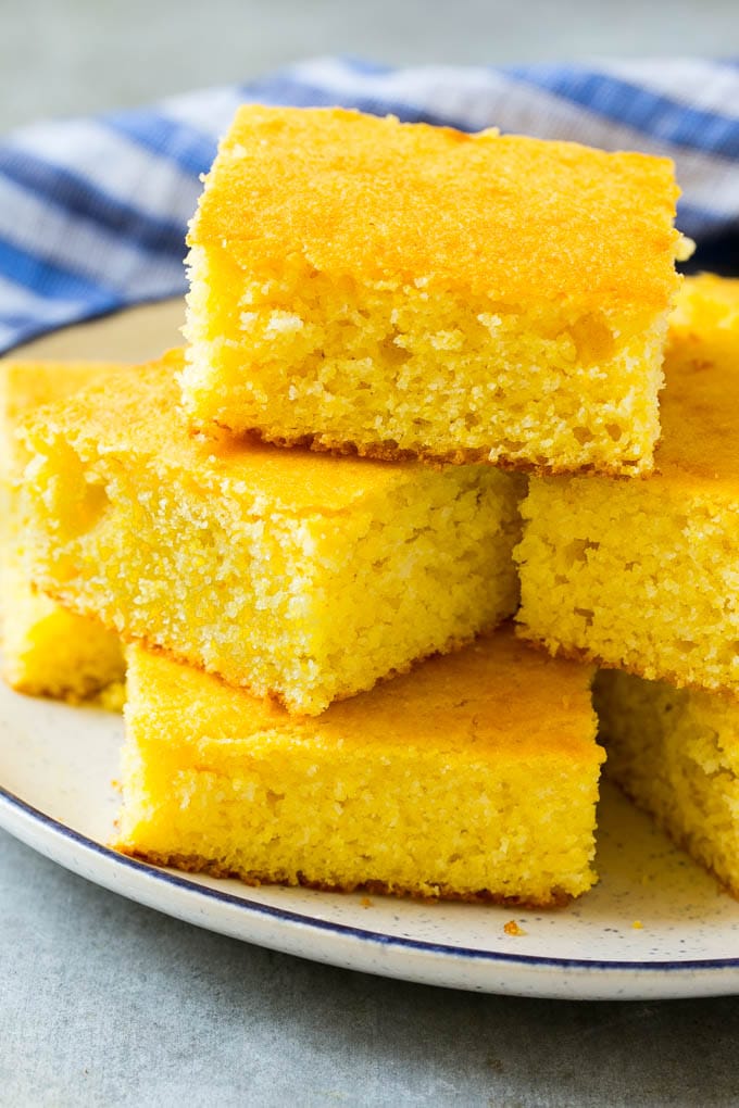 A plate full of squares of bread made with cornmeal.