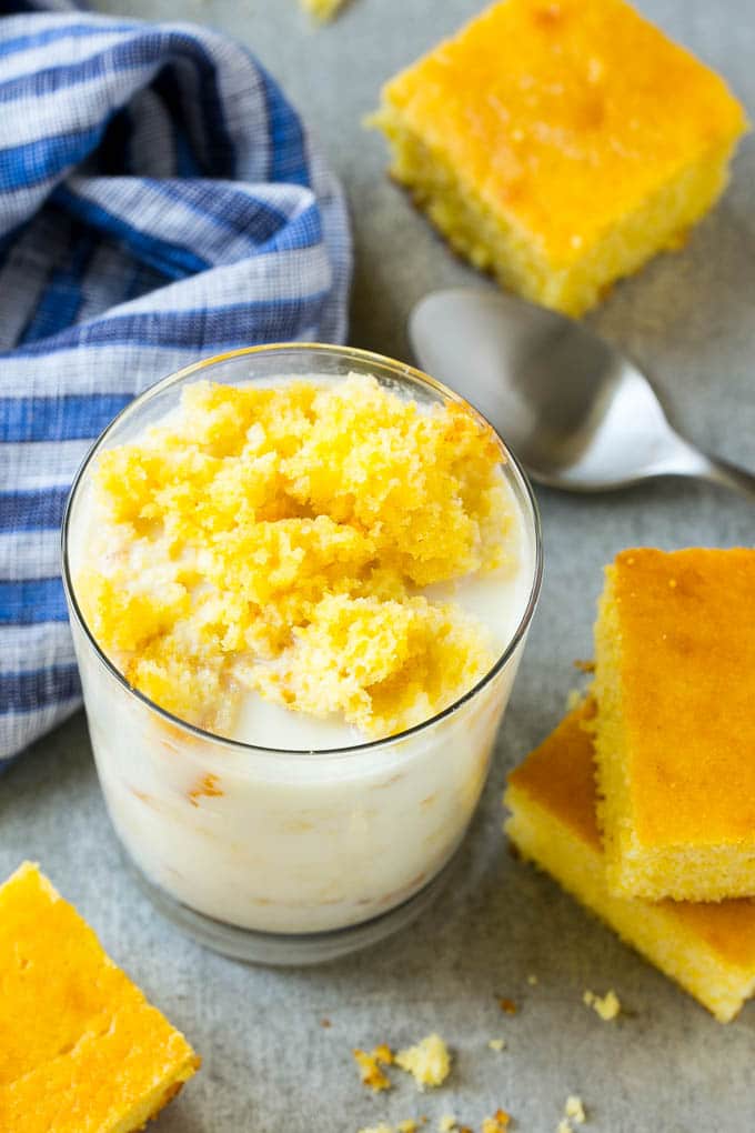 A glass of milk with cornbread crumbled into it.