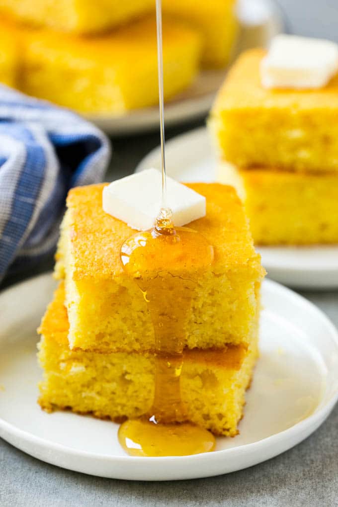 A stack of cornbread topped with butter and honey