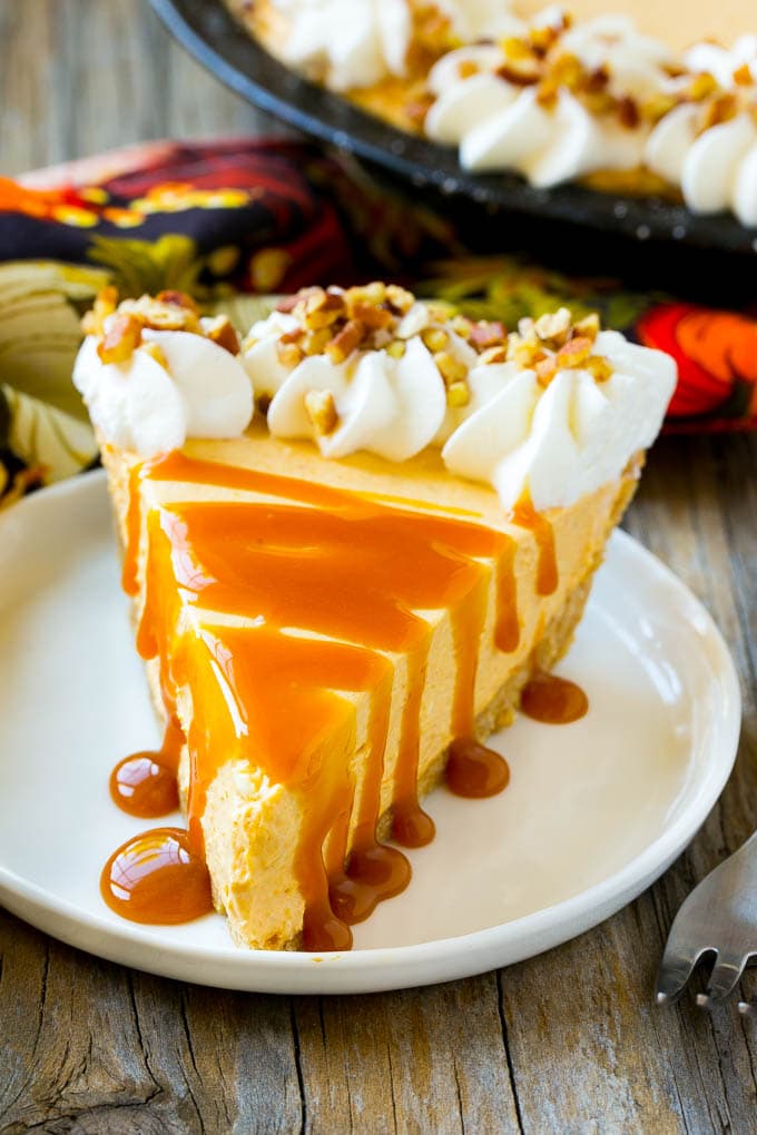 A slice of pumpkin cheesecake topped with a caramel drizzle.
