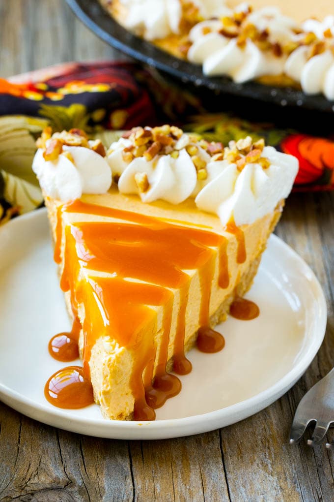 No Bake Pumpkin Cheesecake Recipe | Pumpkin Cheesecake | No Bake Cheesecake | Thanksgiving Dessert | Pumpkin Dessert #nobake #cheesecake #pumpkin #pumpkinpie #pumpkincheesecake #nobakecheesecake #dessert #dinneratthezoo A slice of cheesecake topped with a caramel drizzle.