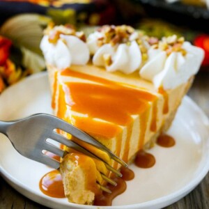 A fork cutting into a slice of no bake pumpkin cheesecake.