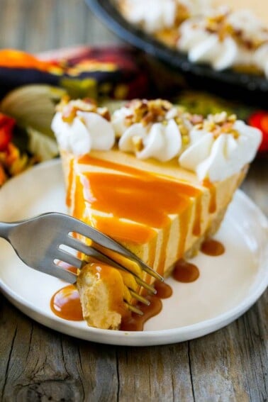 A fork cutting into a slice of no bake pumpkin cheesecake.