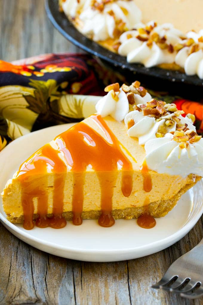 A piece of no bake pumpkin flavored cheesecake topped with caramel.