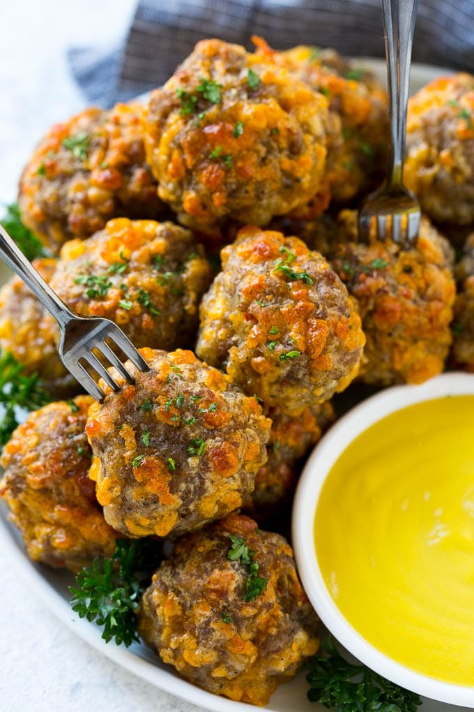 A plate of meatballs with cocktail forks.