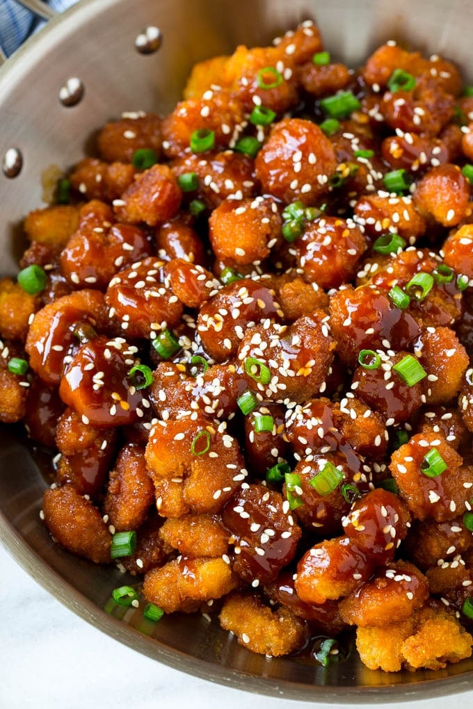 A pan of popcorn shrimp in an Asian sesame sauce.