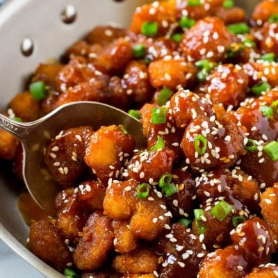 A pan of crispy sesame shrimp tossed in an Asian style sauce.