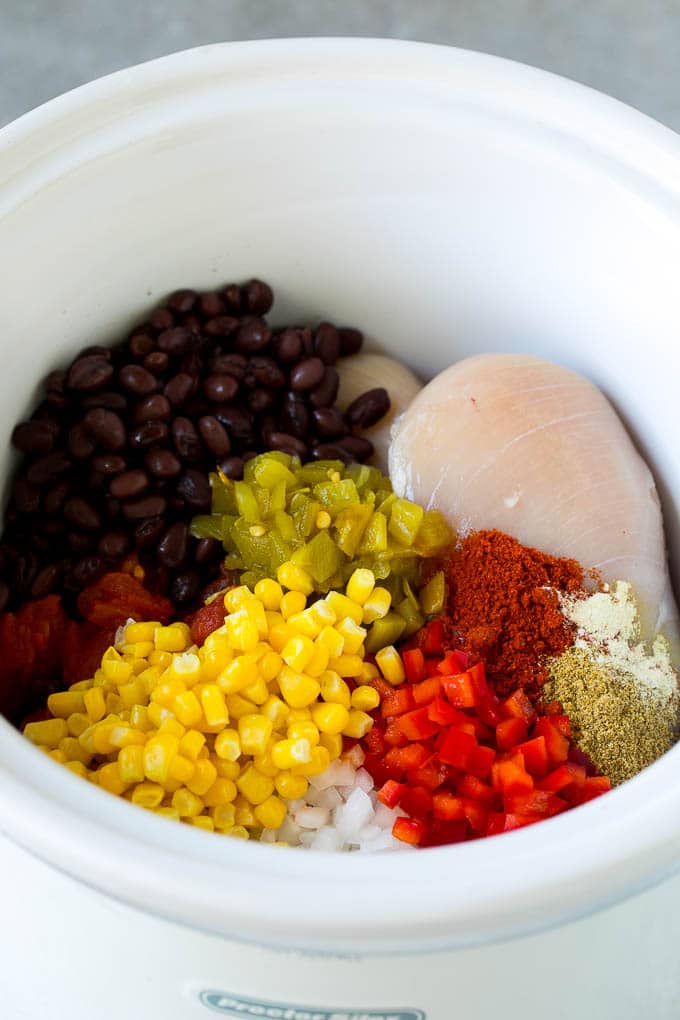 Chicken breasts with vegetables and spices in a crock pot.