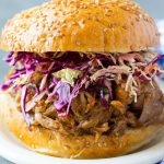 A pulled pork sandwich topped with slaw.