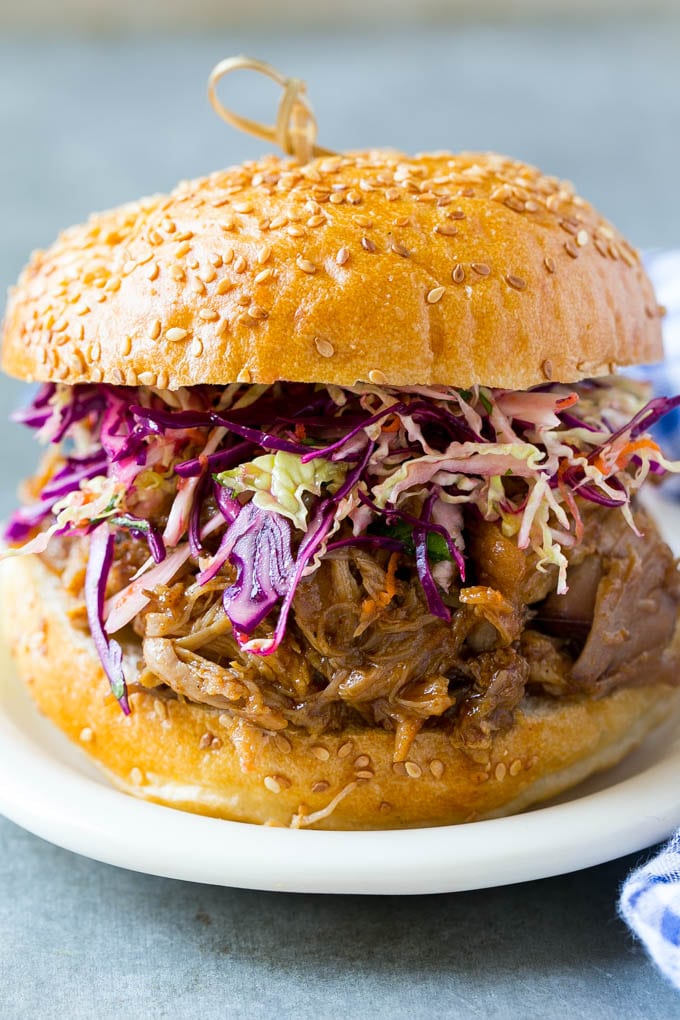 A slow cooker pulled pork sandwich topped with slaw.
