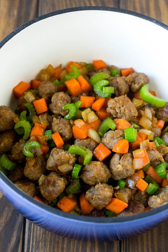 Sausage, carrots, onion and celery in a pot.