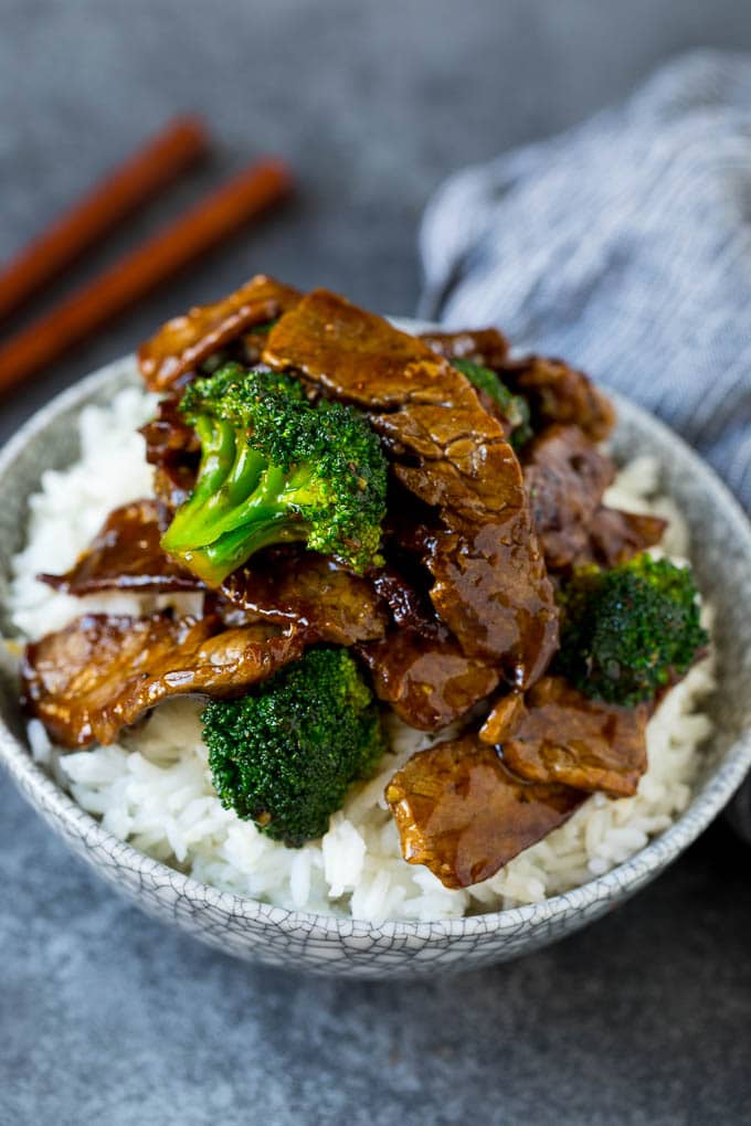 A bowl of beef and broccoli stir fry served over rice.