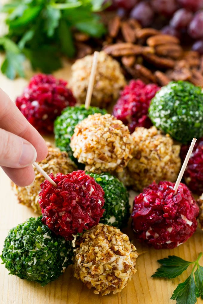 A hand reaching for an appetizer crusted in dried craberries.