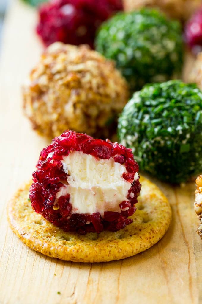 A cranberry crusted ball of cheese on a cracker.