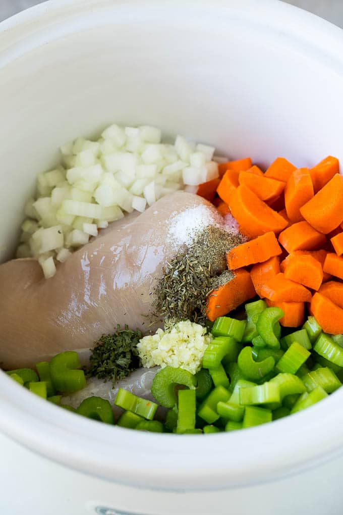 Chicken, vegetables and spices in a crock pot.