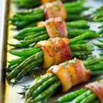 A row of green bean bundles on a pan.