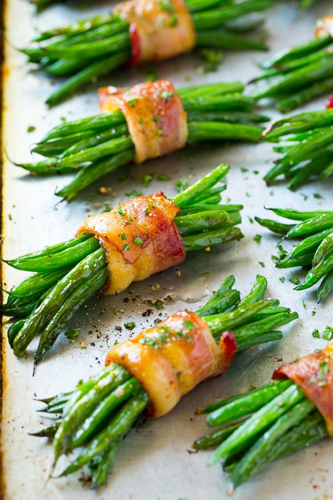 Bacon wrapped green bean bundles on a sheet pan.