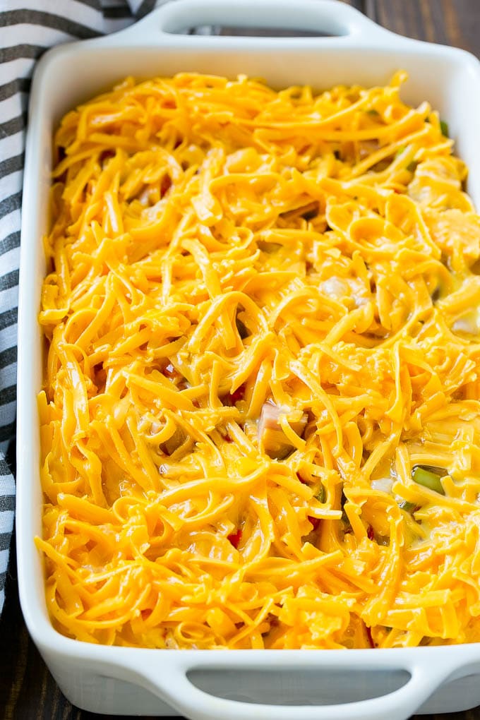 Unbaked Egg Casserole with a layer of shredded cheese on top.