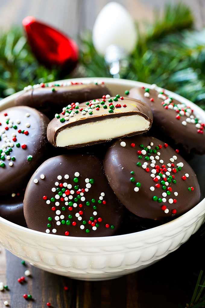 A bowl of peppermint patties with one cut in half.