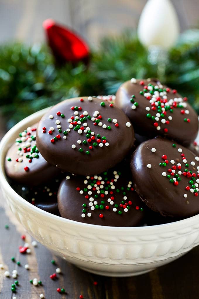 A white bowl filled with chocolate covered peppermint patties.