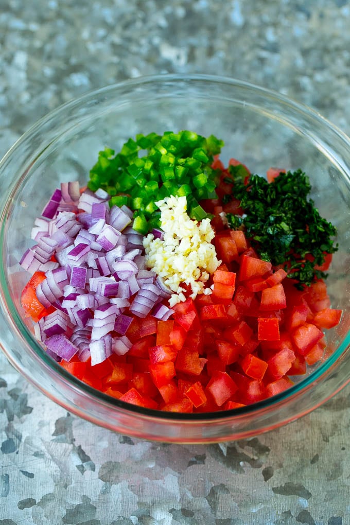 Diced tomatoes, onion, garlic, jalapeno and cilantro in a bowl.