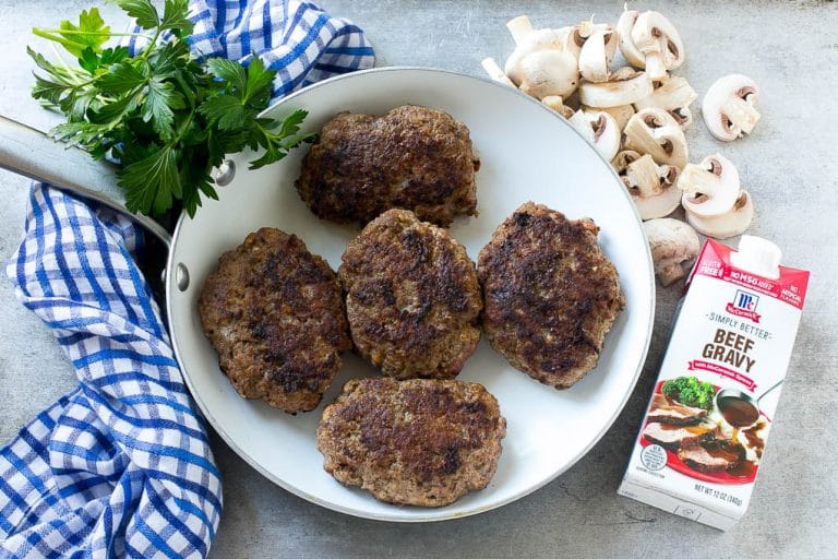 Hamburger patties browned in a skillet.