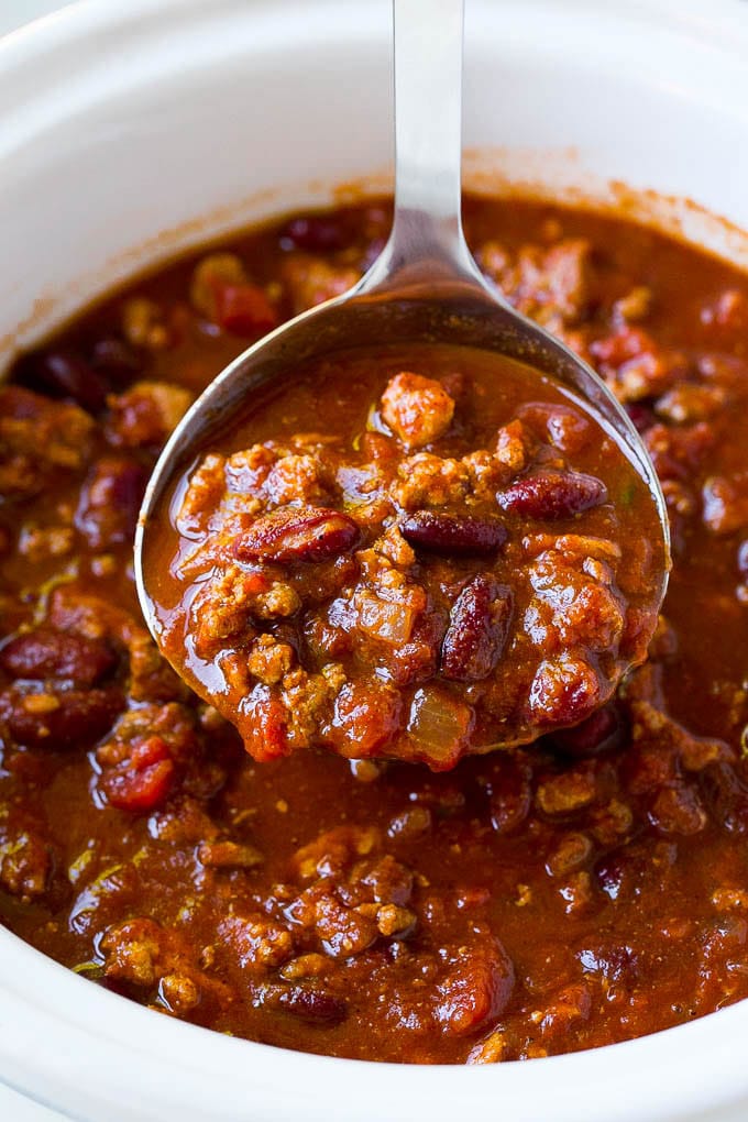 A ladle serving up a portion of slow cooker turkey chili.