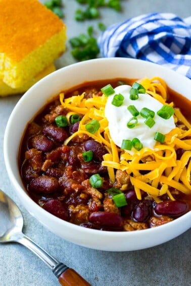 A bowl of slow cooker turkey chili topped with sour cream and cheese.