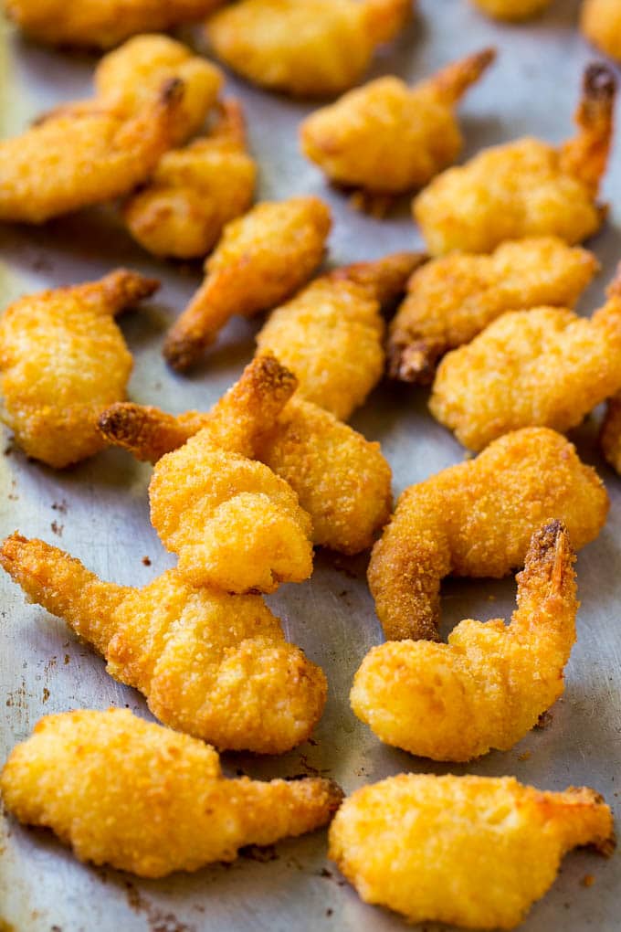 Breaded cooked shrimp on a sheet pan.