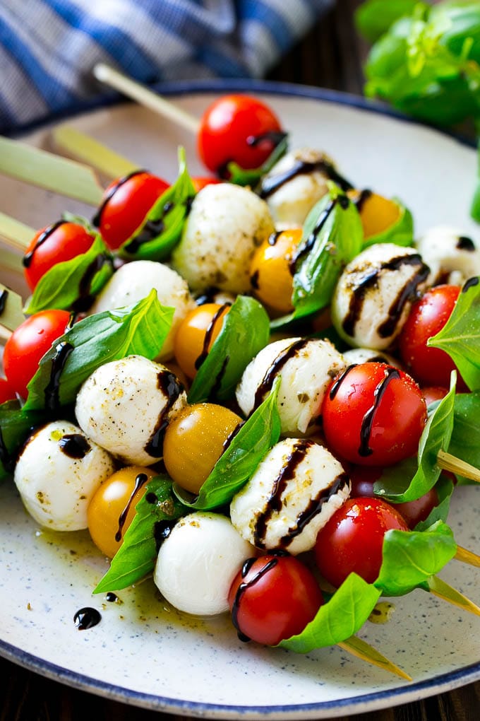 Caprese skewers with mozzarella, cherry tomatoes and basil with balsamic glaze.