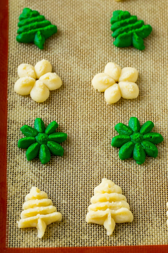 Spritz cookies piped onto a baking sheet.