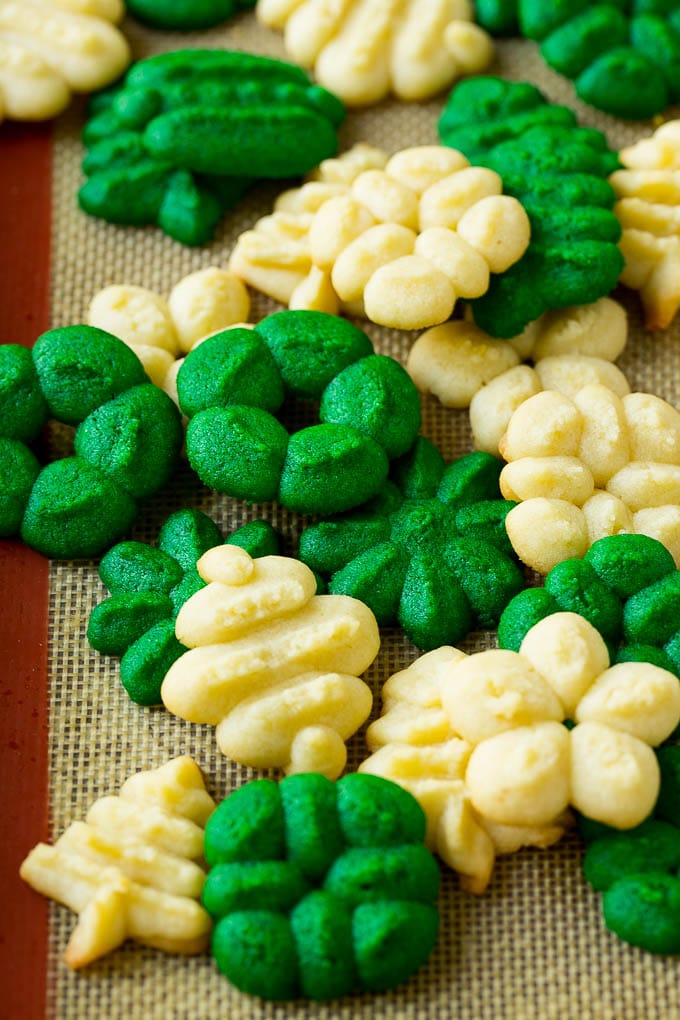 Baked green and white spritz cookies on a baking sheet.