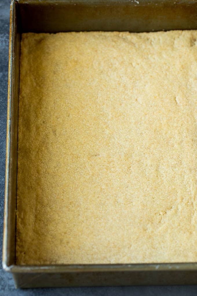 A shortbread crust in a baking pan.