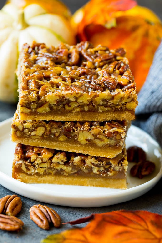 A stack of pecan pie bars on a plate.