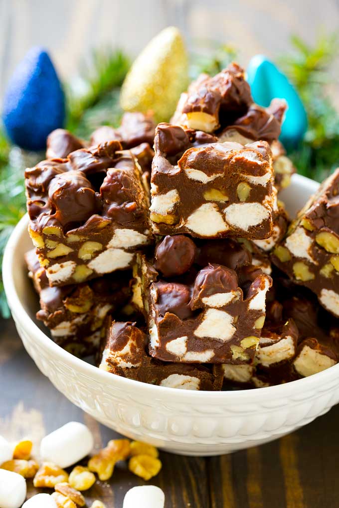 A bowl of fudge squares with holiday decorations in the background.