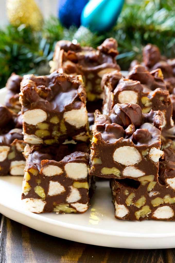 Rocky Road Fudge | Chocolate Marshmallow Fudge | Chocolate Nut Fudge | Microwave Fudge #fudge #chocolatefudge #nobake #chocolate #dessert #rockyroad #dinneratthezoo Rocky Road Fudge cut into squares on a serving plate.