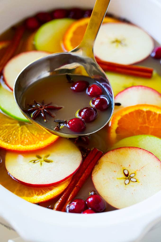 A ladle scooping out some slow cooker apple cider.