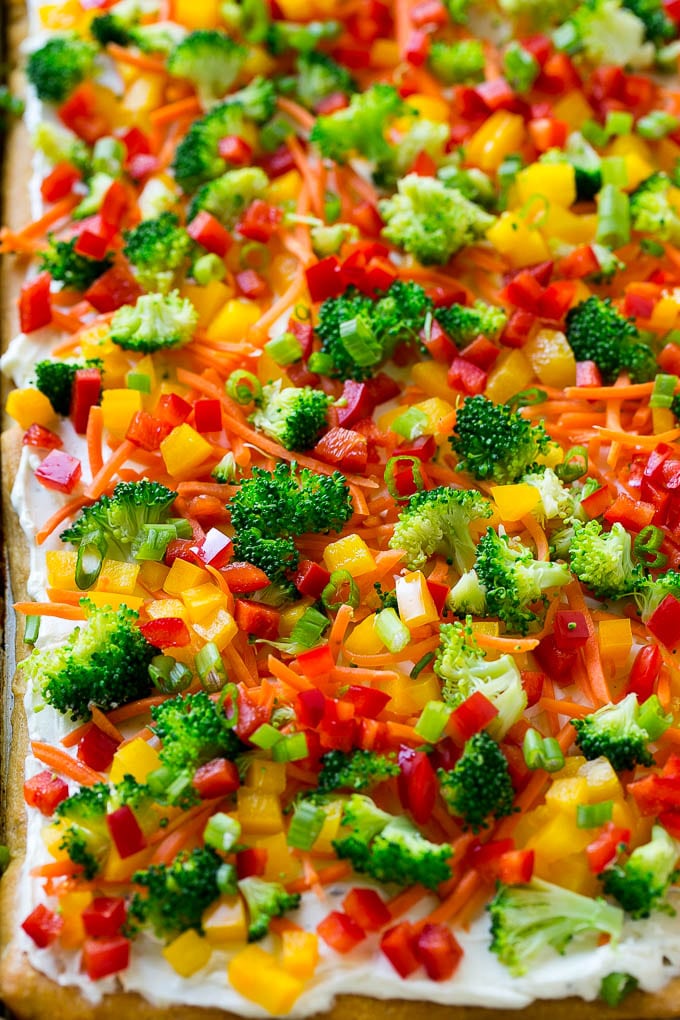 Veggie pizza on a crescent roll crust with colorful fresh vegetables.