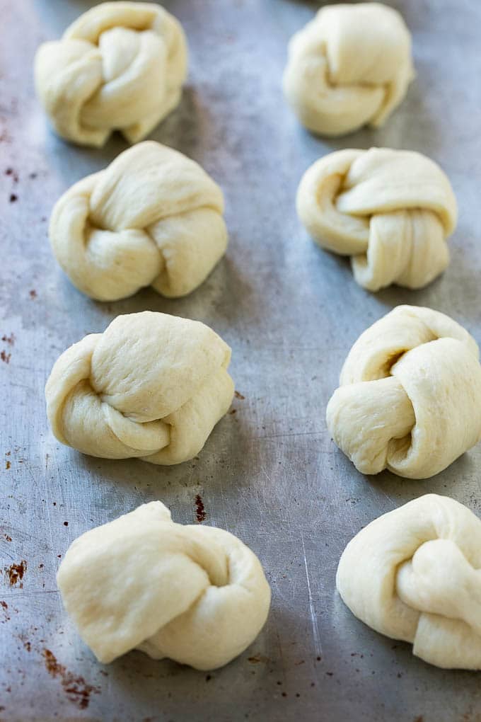 Pizza dough tied up and placed on a sheet pan.