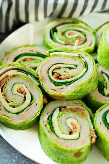 These turkey roll ups are pinwheel sandwiches filled with cheese, avocado, bacon, turkey and spinach.