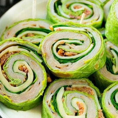 These turkey roll ups are pinwheel sandwiches filled with cheese, avocado, bacon, turkey and spinach.