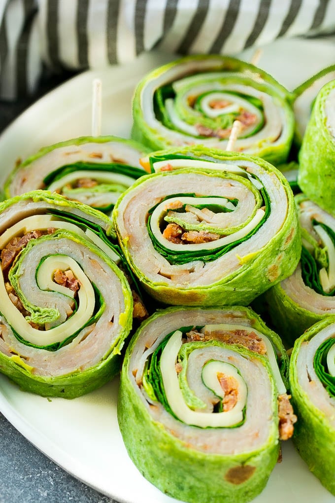 These turkey roll ups are pinwheel sandwiches filled with cheese, avocado, bacon, turkey and spinach.
