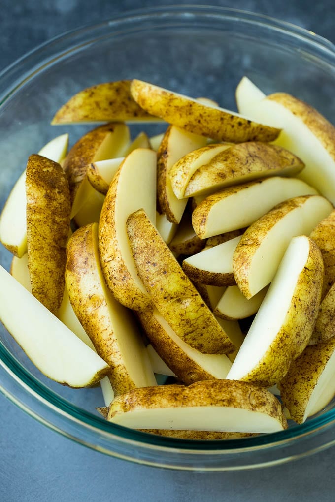 A bowl of potatoes cut into wedges.