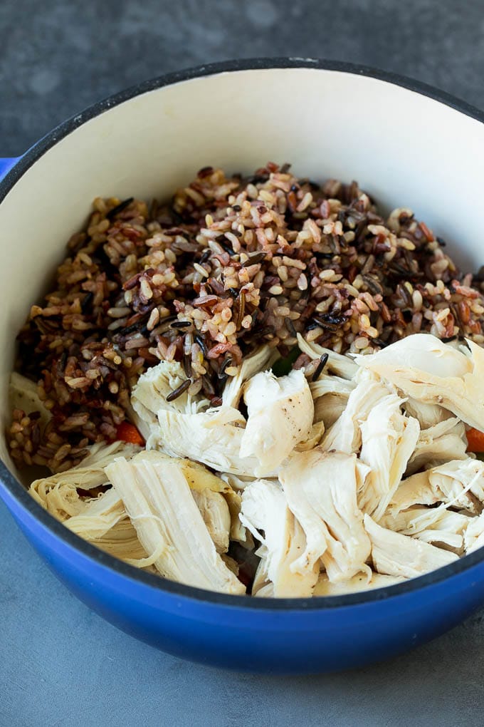 Shredded chicken and wild rice in a soup pot.