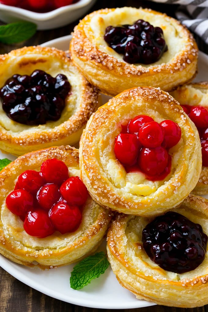 Cream cheese danish topped with cherries and blueberries.